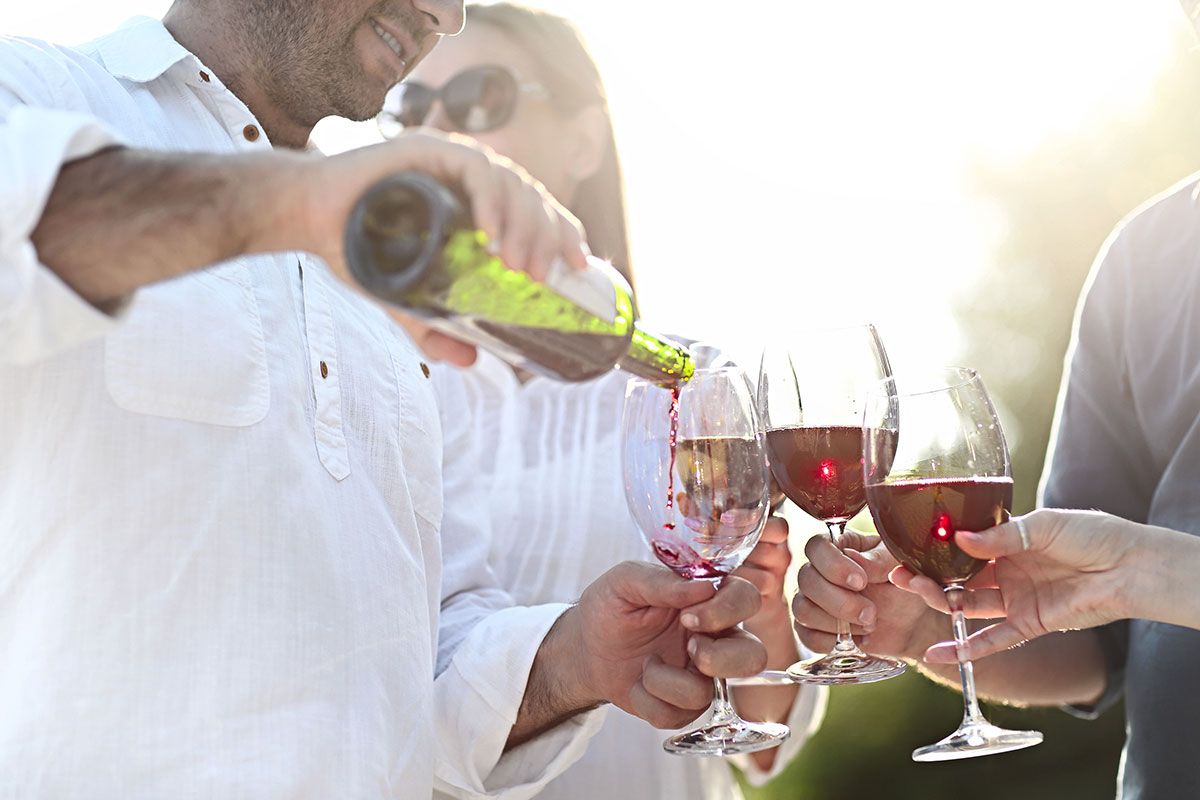 Vier Personen trinken zusammen Rotwein