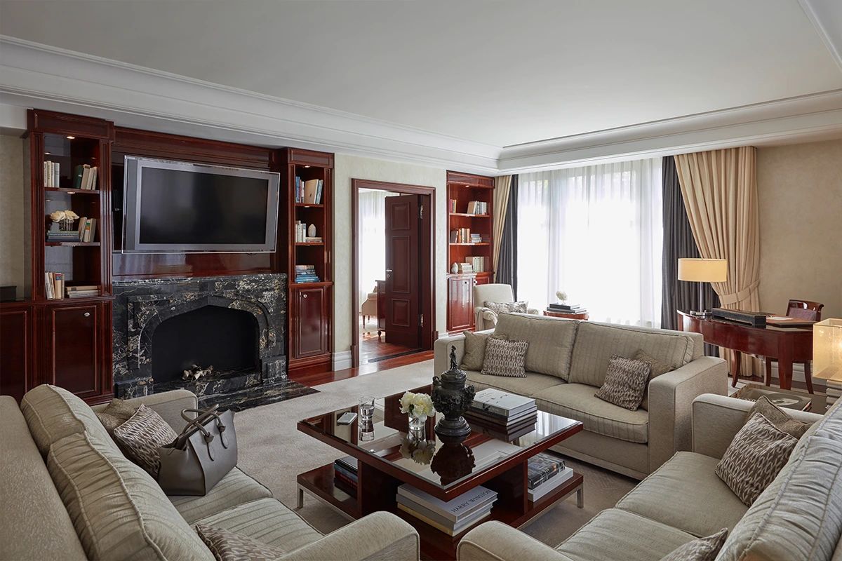 Luxuriöser Wohnbereich mit Mamorkamin und drei Sofas mit Beistelltisch und Flügel im Hintergrund
