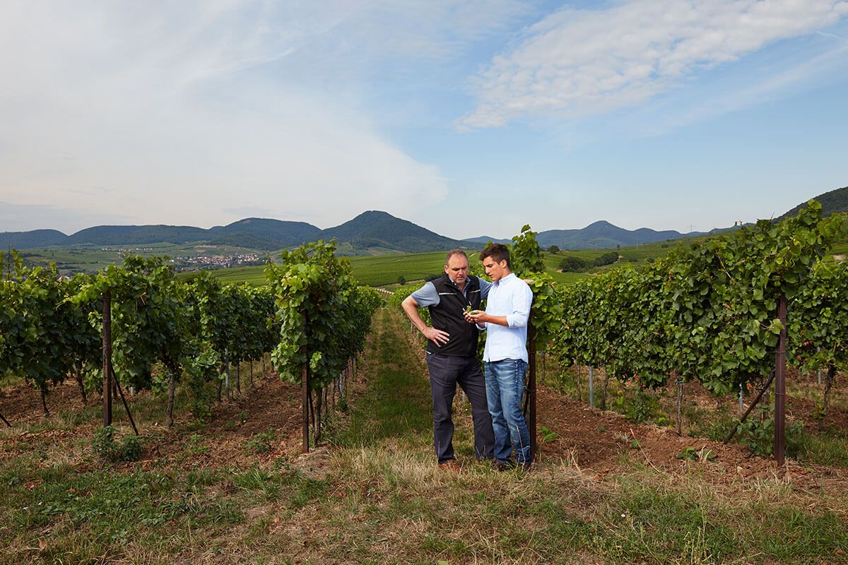 2 men are standing on a farm and talking